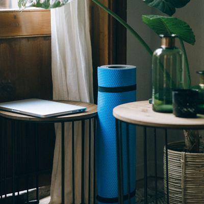 A yoga mat rolled out in a peaceful, sunlit room.
